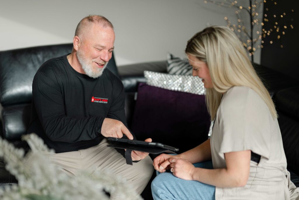 home inspector showing home owner and realtor inspection report on tablet